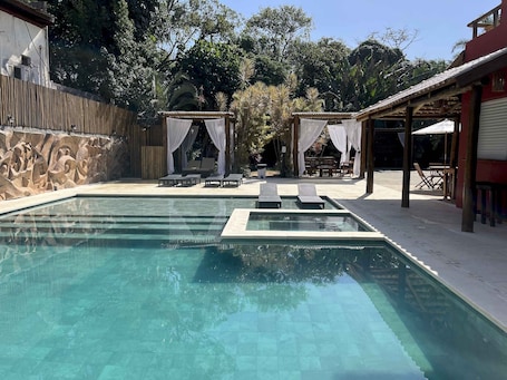 Una piscina al aire libre, sillones reclinables de piscina