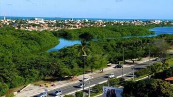 A coastal cityscape with a river, roads, and greenery.