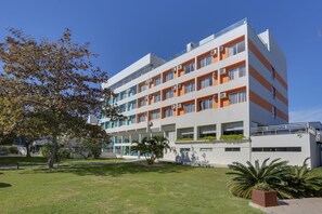 Un hôtel à plusieurs étages, doté d’un design moderne, avec des balcons et des unités de climatisation.