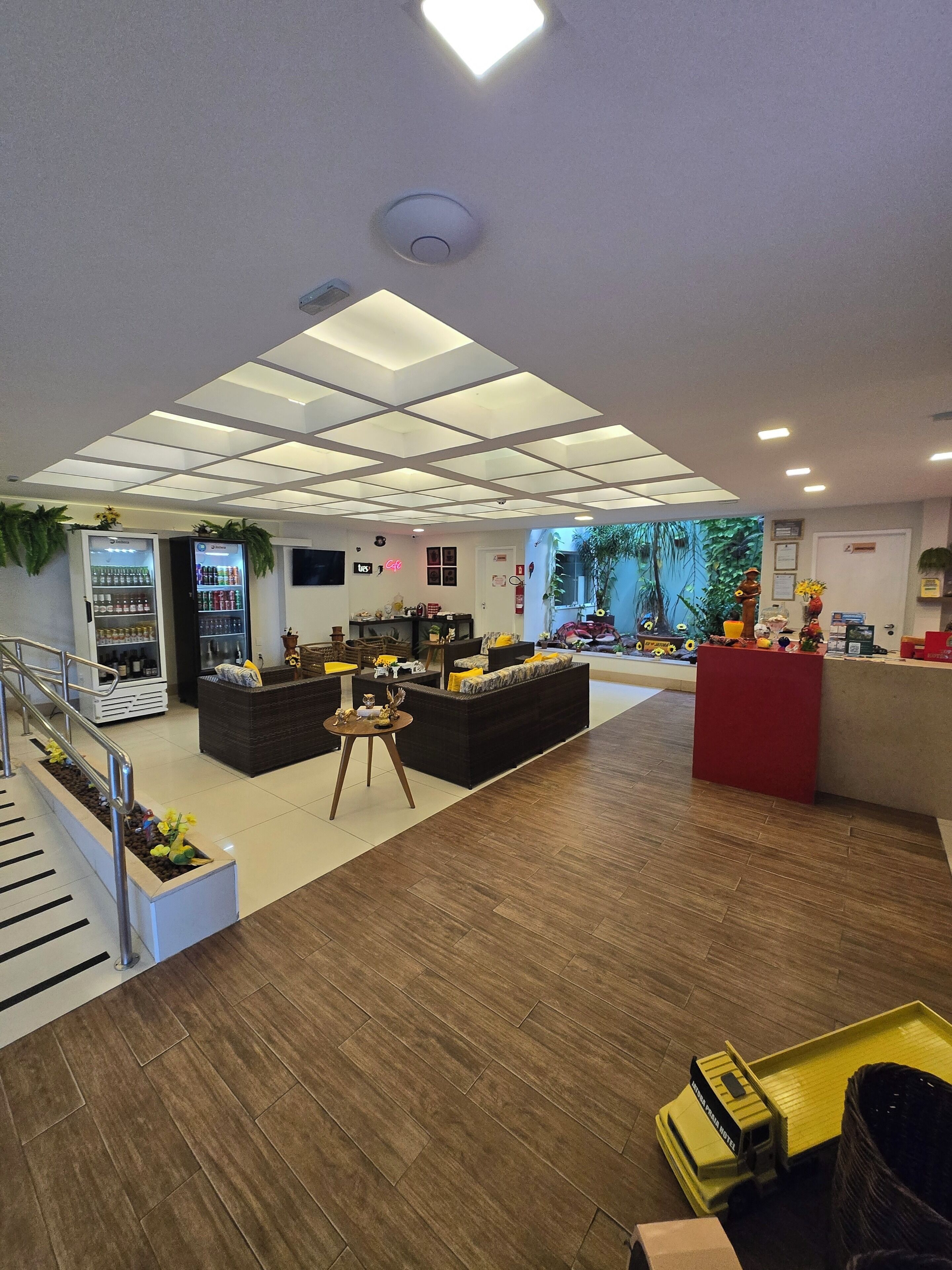 Un vestíbulo de hotel con recepción, zona de estar y escalera.