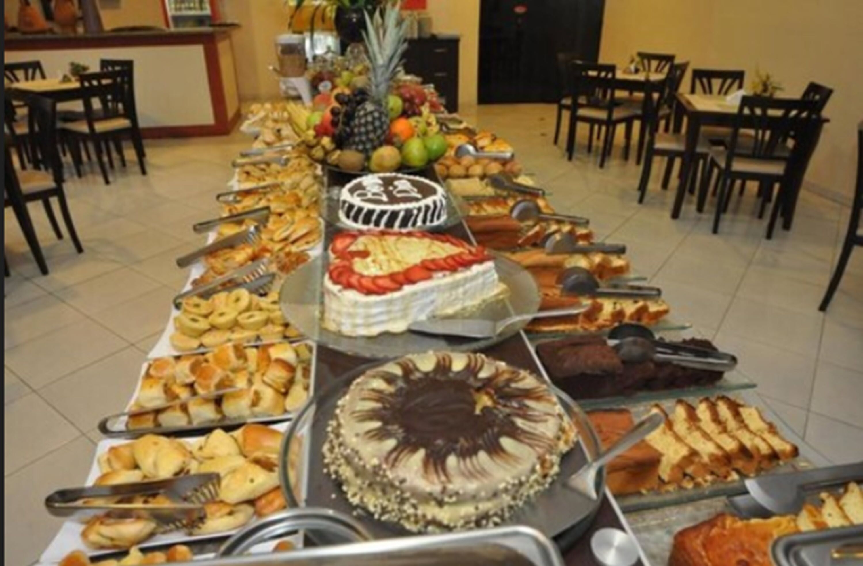 A buffet with various food items including cakes, pastries, and fruits.