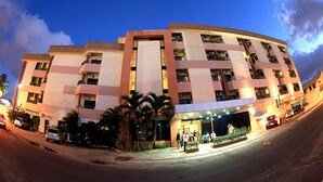 A multi-story hotel with a modern design, featuring balconies and a well-lit entrance. - Sandrin Praia Hotel (Aracaju)