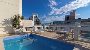 A rooftop pool area with a clear blue sky, a pool, and lounge chairs. - Rio Branco Apart Hotel (Florianópolis)