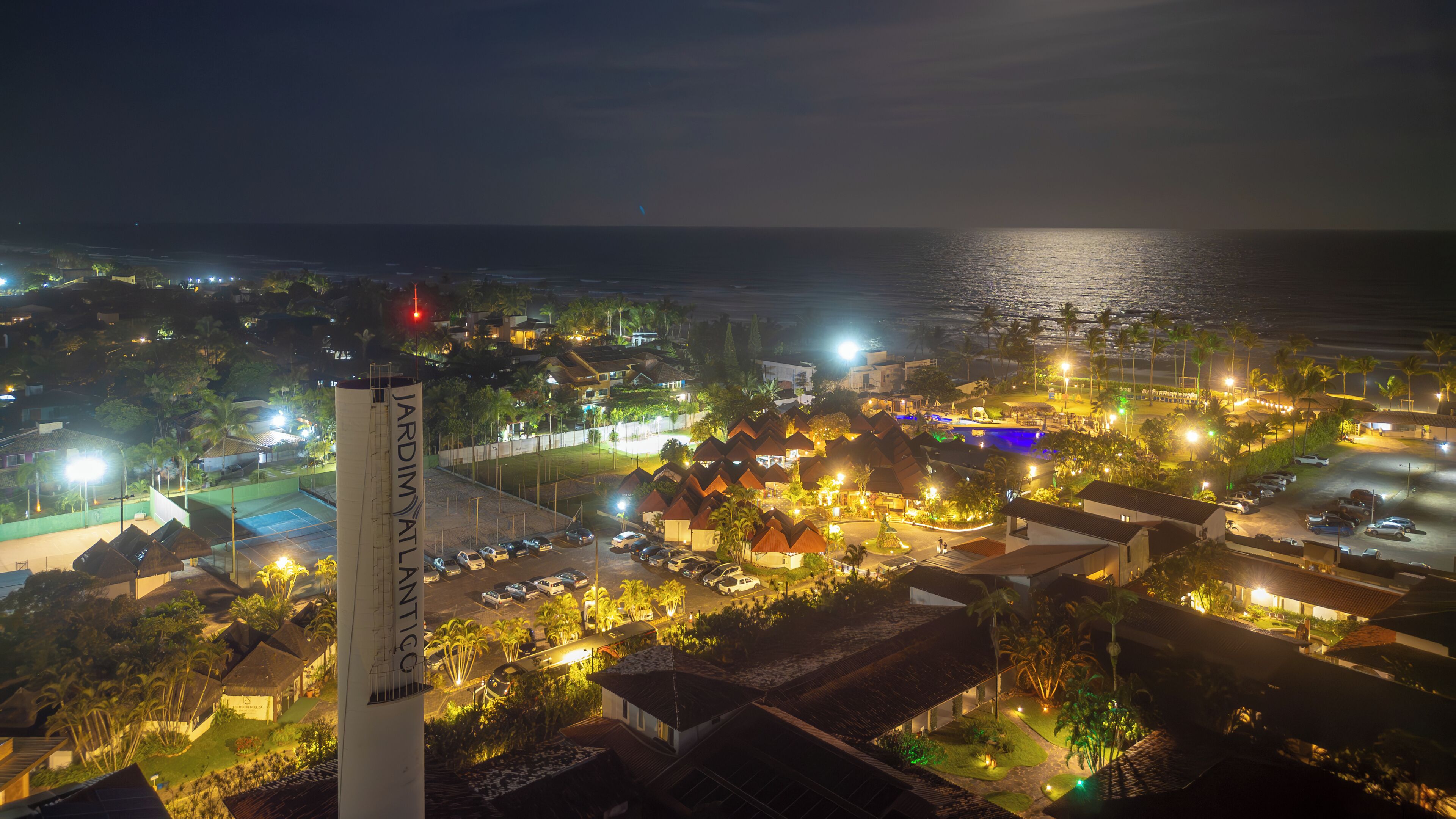 A coastal resort with multiple bungalow-style accommodations, a swimming pool, and a view of the ocean.