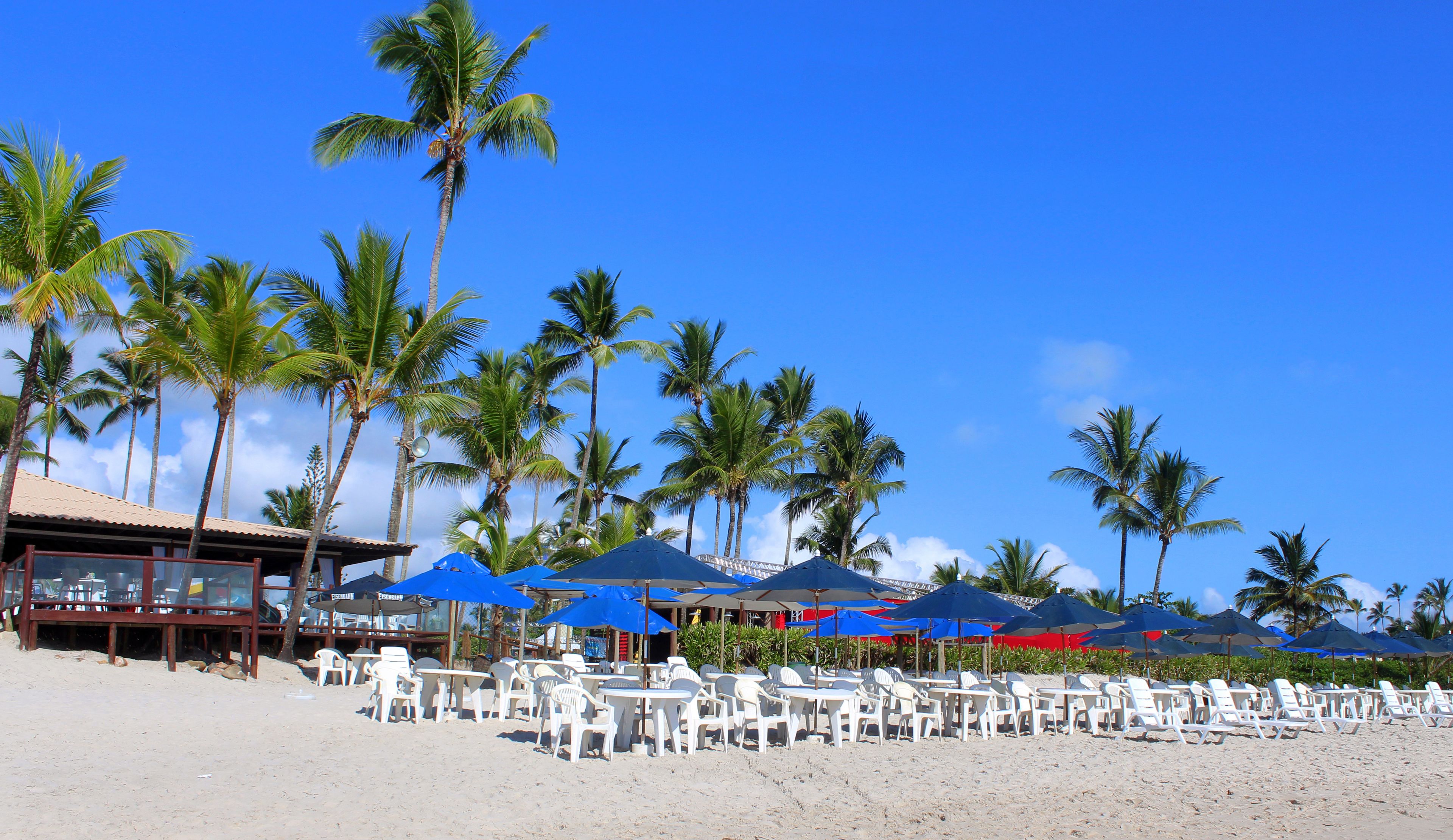 Aan het strand, wit zand, ligstoelen aan het strand, parasols