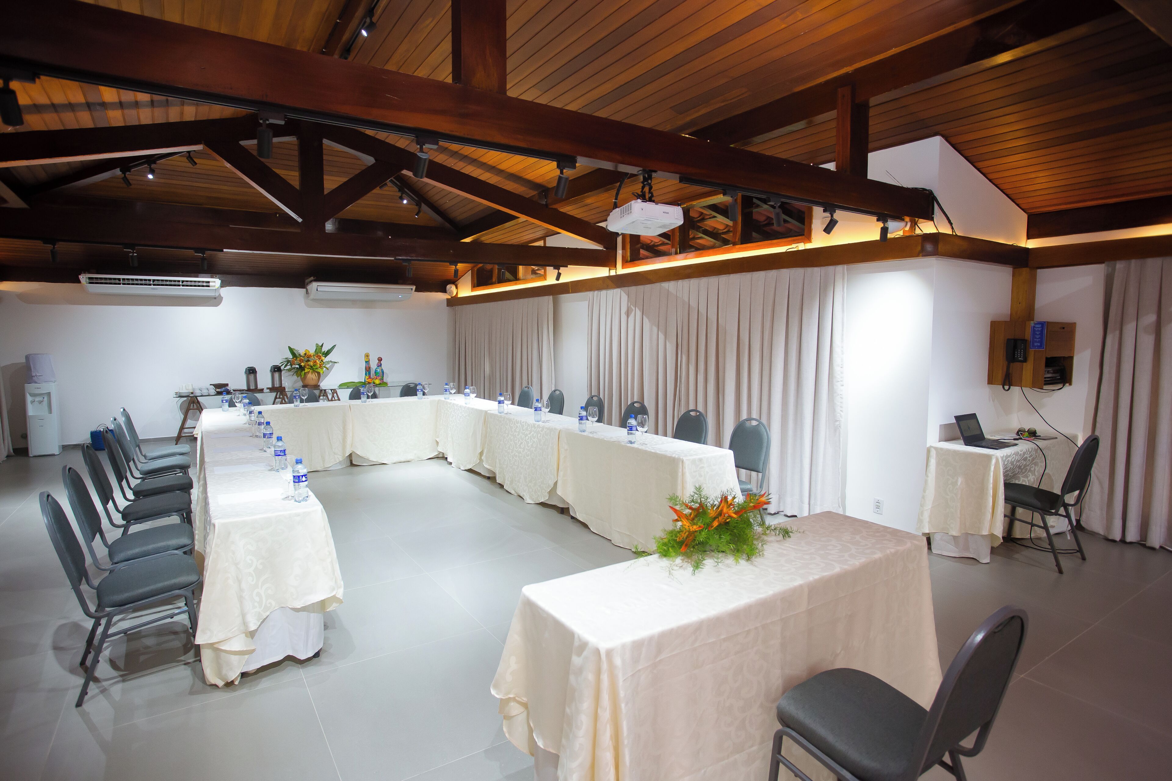 A conference room with a long table, chairs, and a projector.
