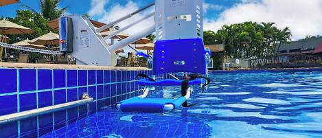 A pool with a blue tiled edge and a lifeguard stand.