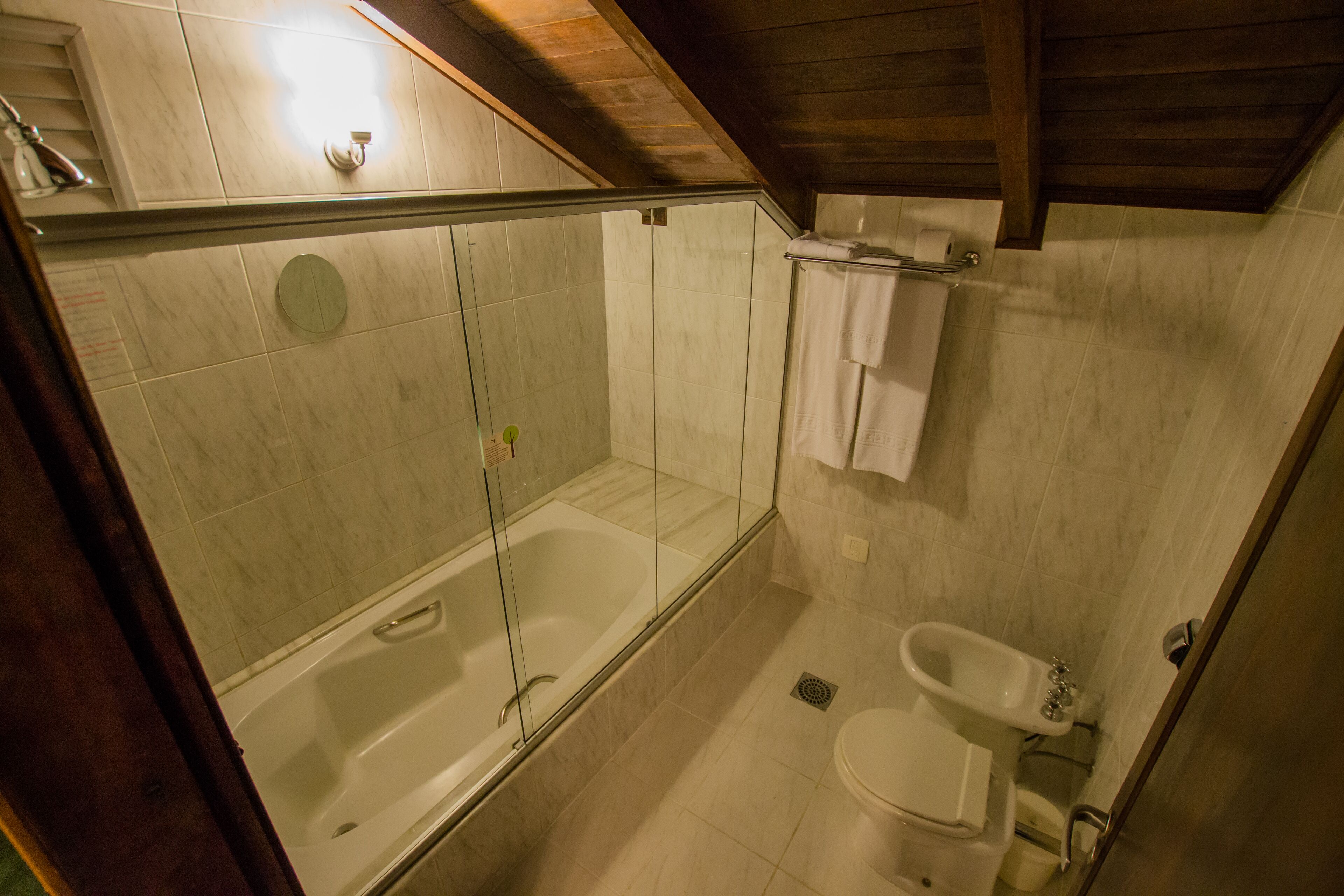 Une salle de bain avec une douche à parois de verre, une baignoire, des toilettes et un lavabo.