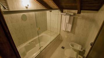 Une salle de bain avec une douche à parois de verre, une baignoire, des toilettes et un lavabo.