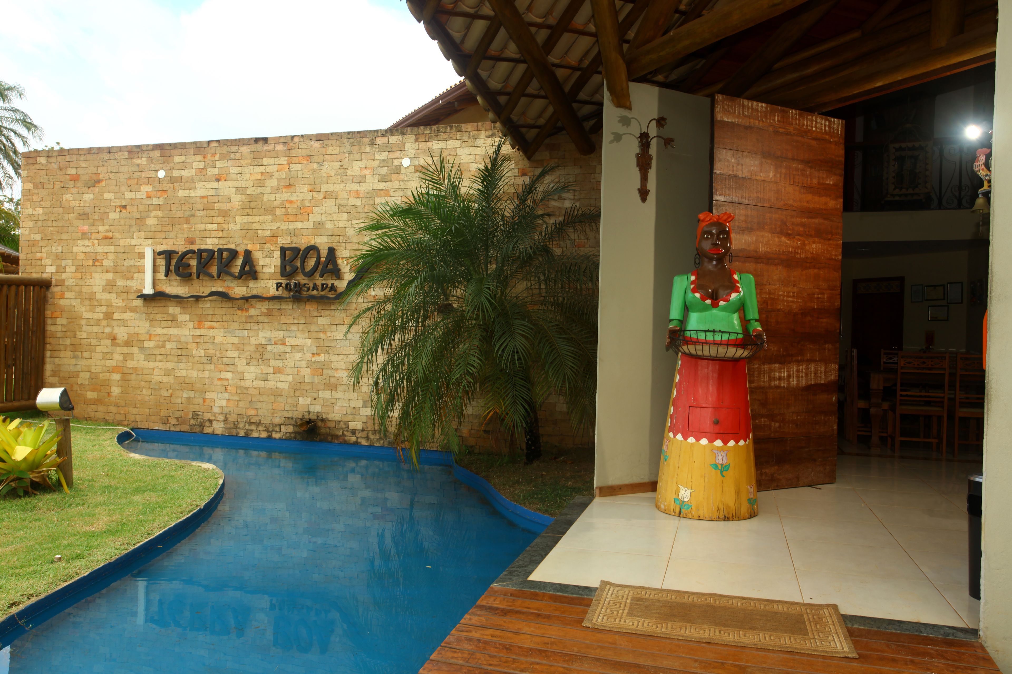 Un edificio de ladrillo con un letrero que dice "TERRA BOA" y una estatua decorativa en su fachada.