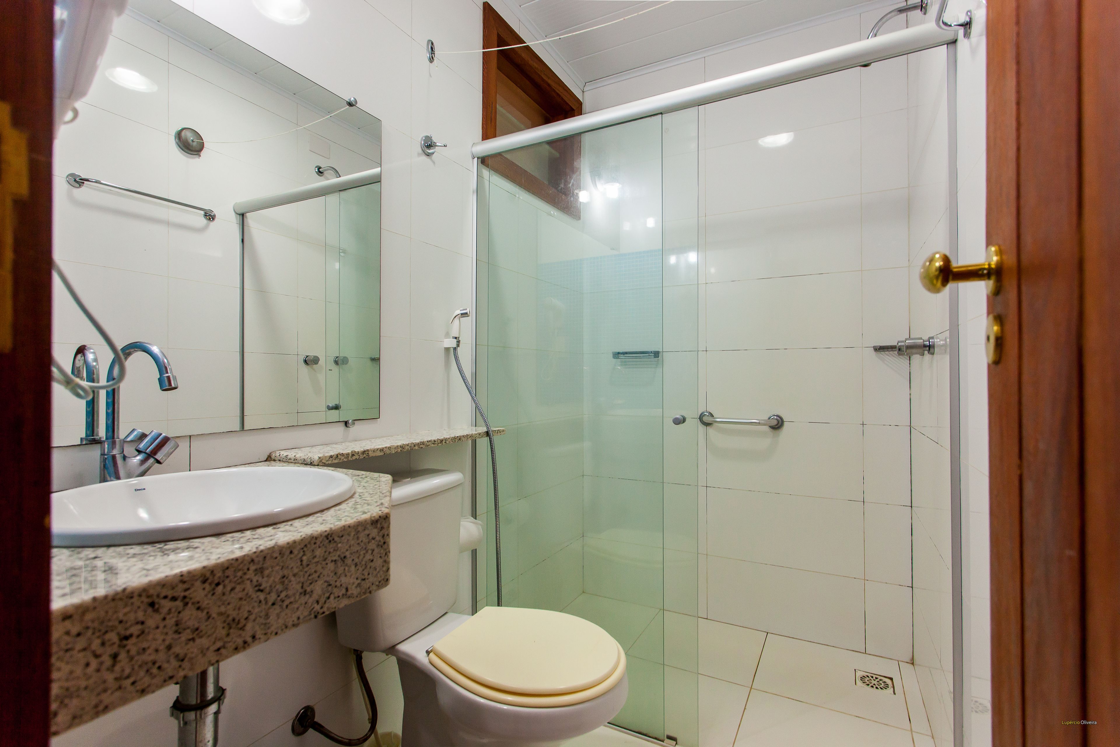 A bathroom with a sink, toilet, and glass-enclosed shower.