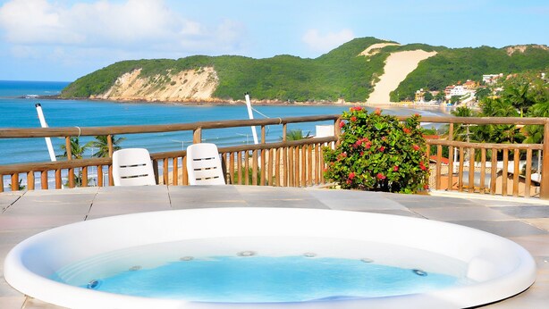A hot tub on a patio with a view of the beach and mountains. - Rede Andrade Bello Mare Comfort (Natal)