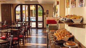 A restaurant with a buffet area featuring various breads, pastries, and desserts. - Rede Andrade Bello Mare Comfort (Natal)