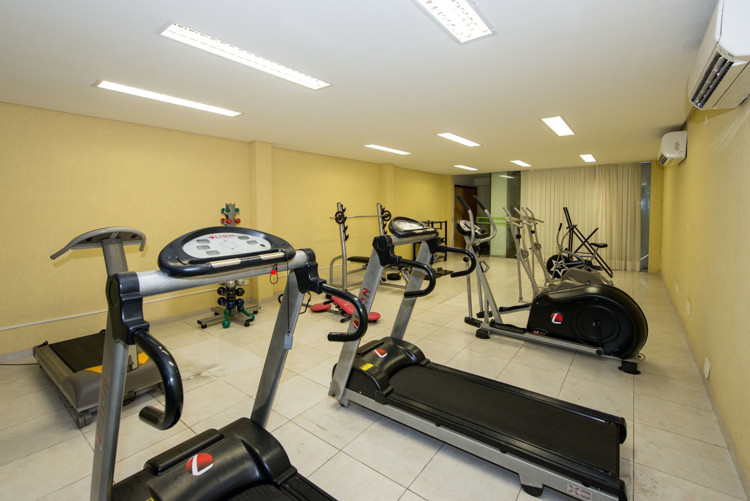 A gym with treadmills, elliptical machines, and stationary bikes.
