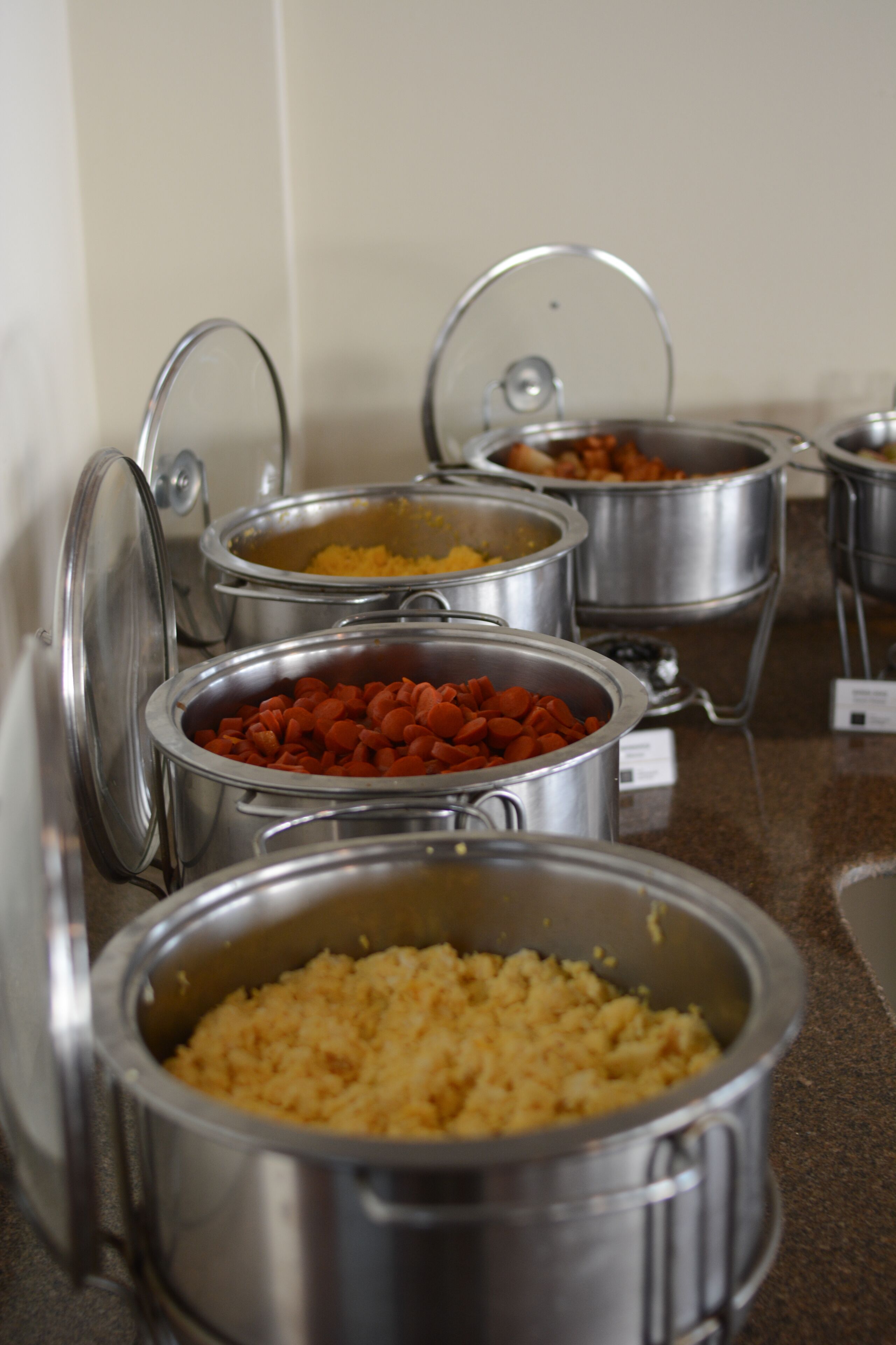 A buffet with various food items in metal containers.