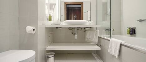 Un baño moderno con inodoro, lavamanos y zona de ducha.