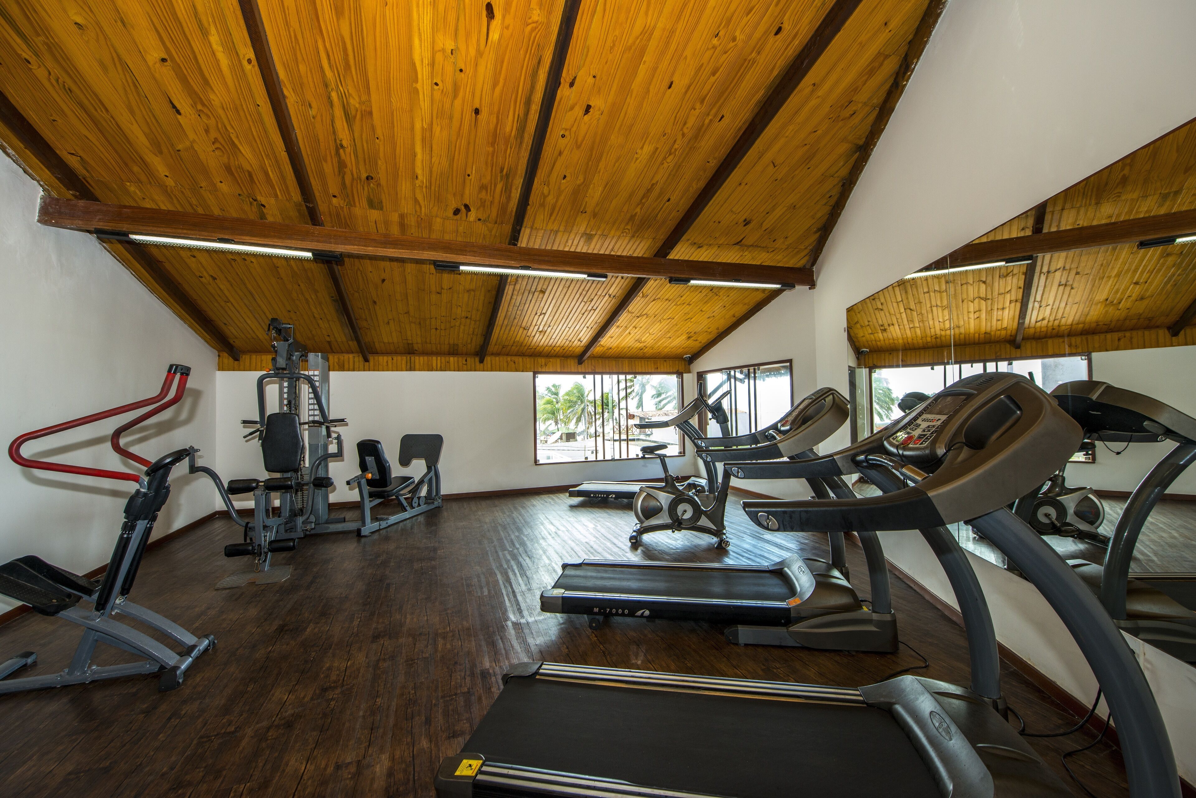 A gym with treadmills, elliptical machines, and weight equipment.
