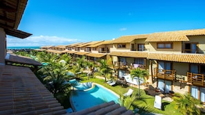 Un resort con varias villas, una piscina y palmeras.