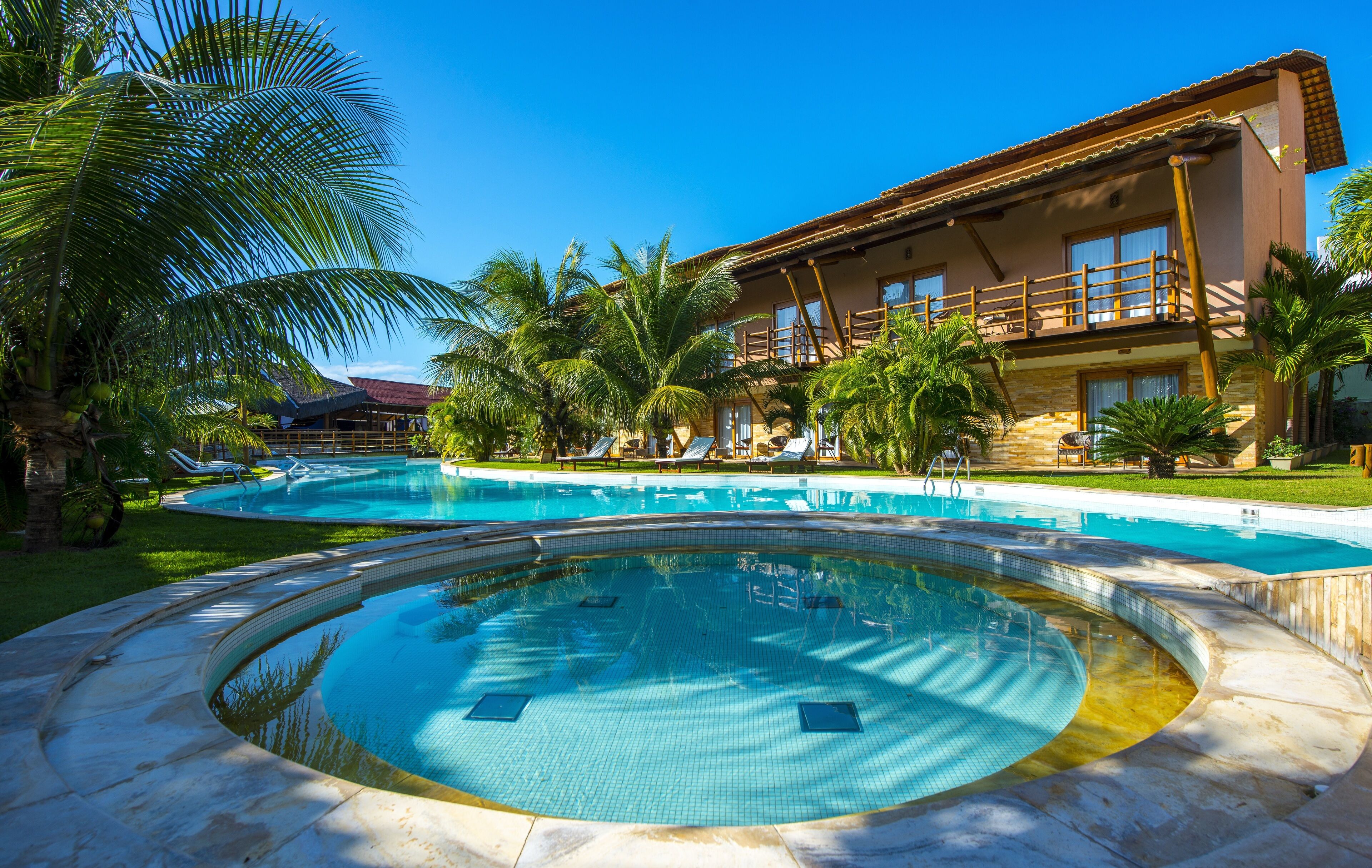 Una piscina al aire libre, sillones reclinables de piscina