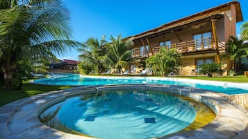 Una piscina al aire libre, sillones reclinables de piscina