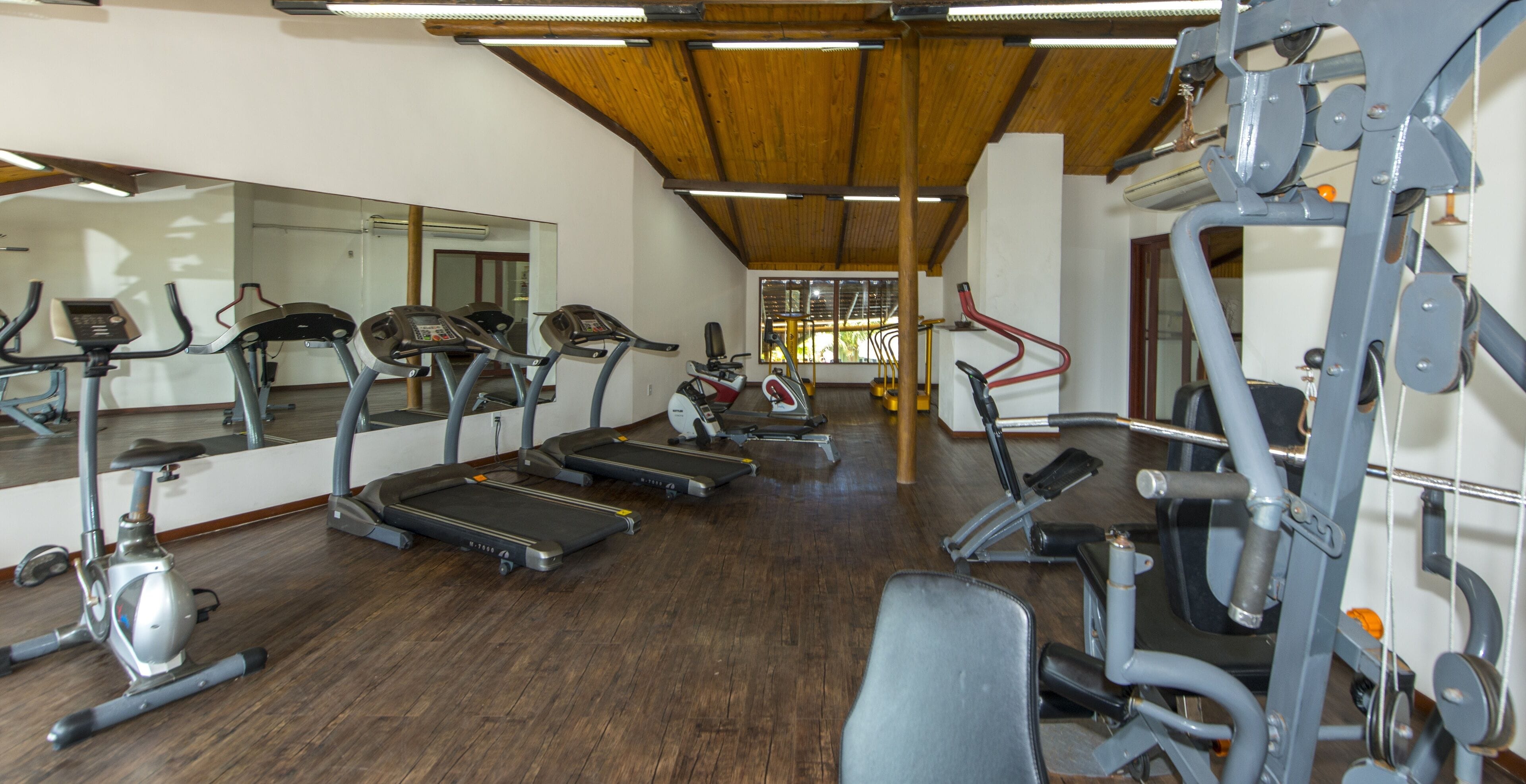 A gym with treadmills, elliptical machines, and weight equipment.