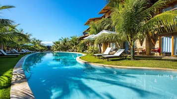 Una piscina al aire libre, sillones reclinables de piscina