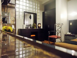 A hotel room with a large mirror, a black wardrobe, a red chair, and a small table with a telephone. - San Francisco Plaza Hotel (Cusco)