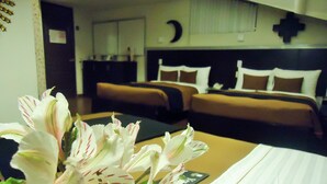 Habitación de hotel con dos camas, una mesita de noche y un reloj de pared.