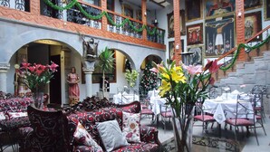 Un comedor con muebles ornamentados, una estatua y decoraciones navideñas.