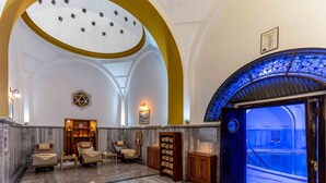 Un vestíbulo lujoso con zona de spa, mostrador de recepción y acceso a la piscina.