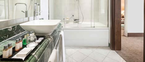 Un baño moderno con un lavamanos grande, espejo y cabina de ducha con mampara de vidrio.