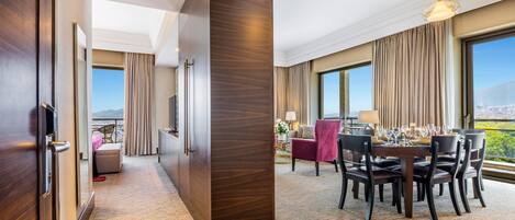 Une chambre d’hôtel avec un coin repas, de grandes fenêtres et une vue sur la ville.