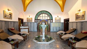 Un cuarto de spa con camillas de masaje, un mostrador de recepción y una fuente decorativa.