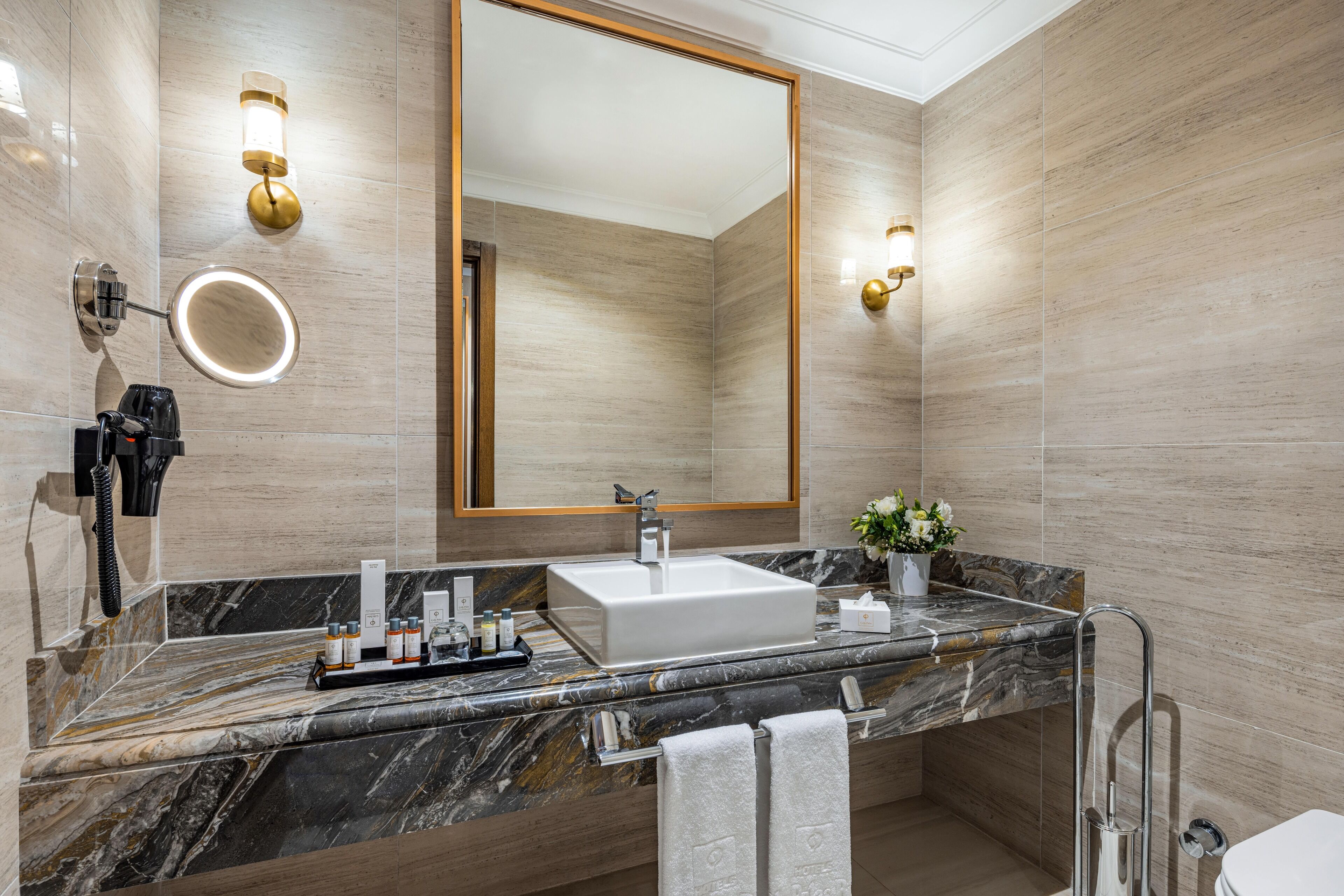 A modern bathroom with a large mirror, a sink, and a vanity.
