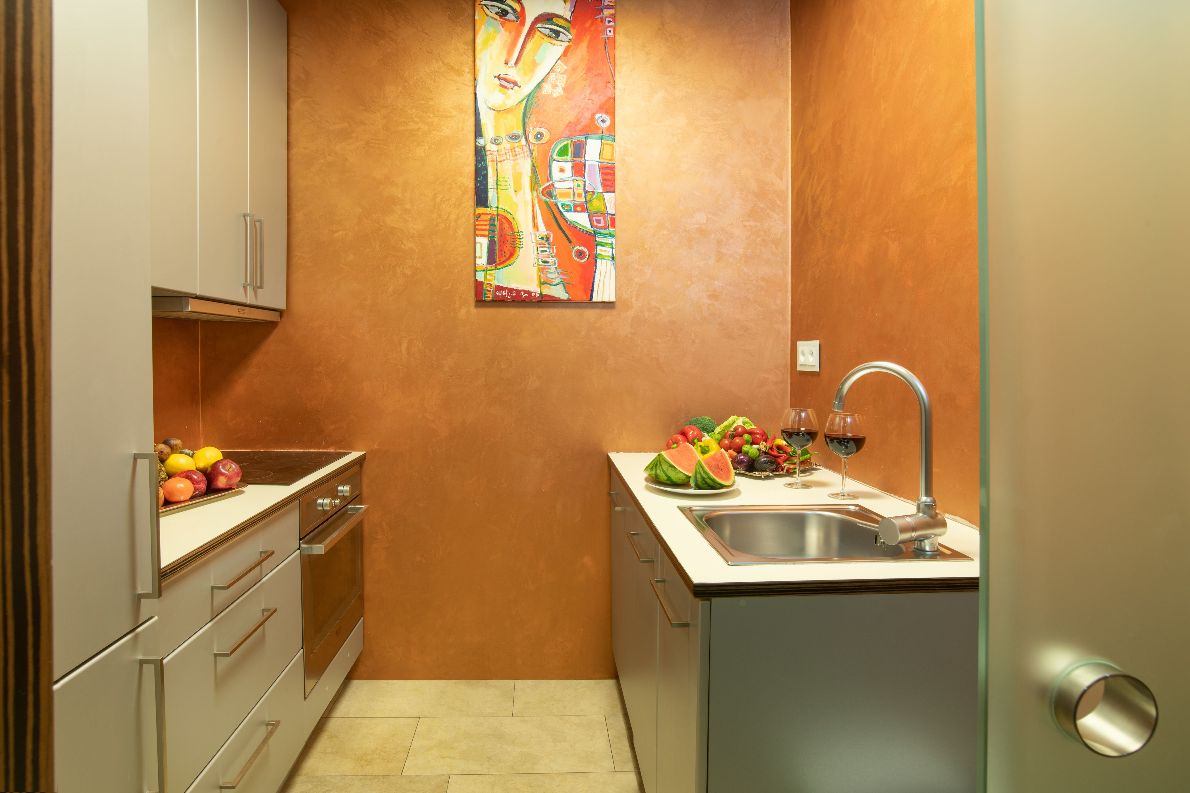 Una cocina compacta con lavamanos, encimera y armarios.