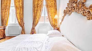 Ein Hotelzimmer mit Bett, Vorhängen, einer Lampe und einem dekorativen Wandbild.