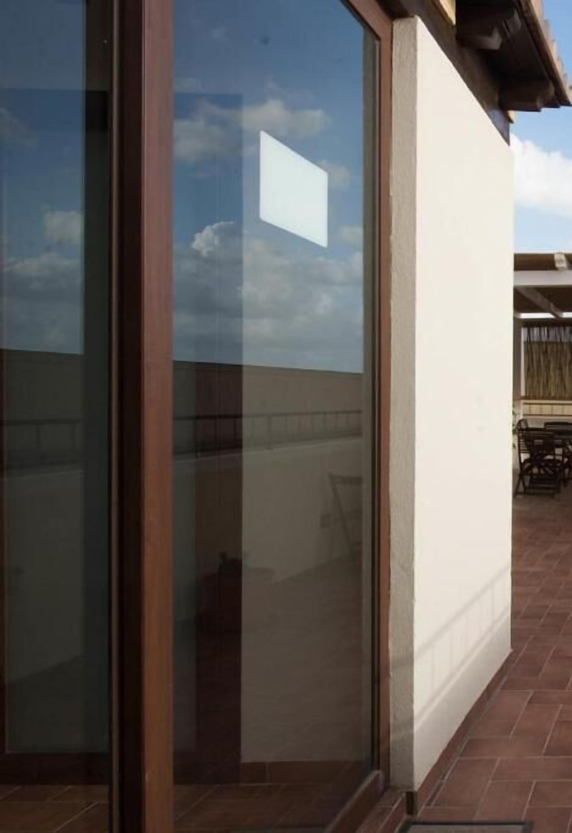 A building with large glass windows and a patio area with outdoor furniture.