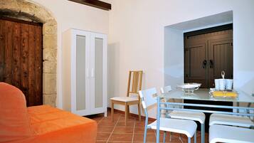 A dining area with a white table, chairs, and a wooden cabinet.