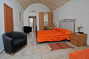 Ένα υπνοδωμάτιο με ένα κρεβάτι, μια καρέκλα, μια συρταριέρα και έναν καθρέφτη.