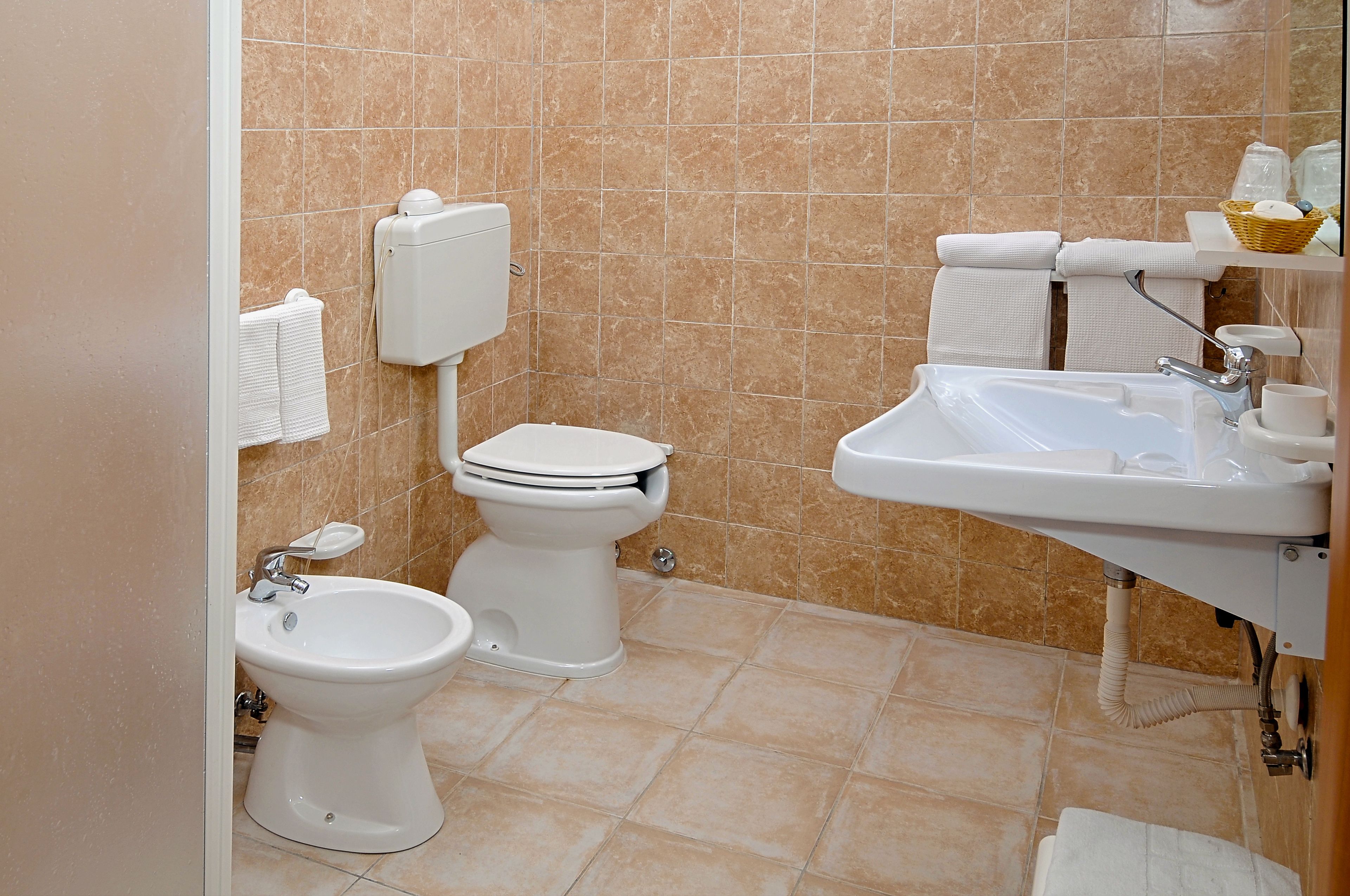 A bathroom with a toilet, bidet, and sink.
