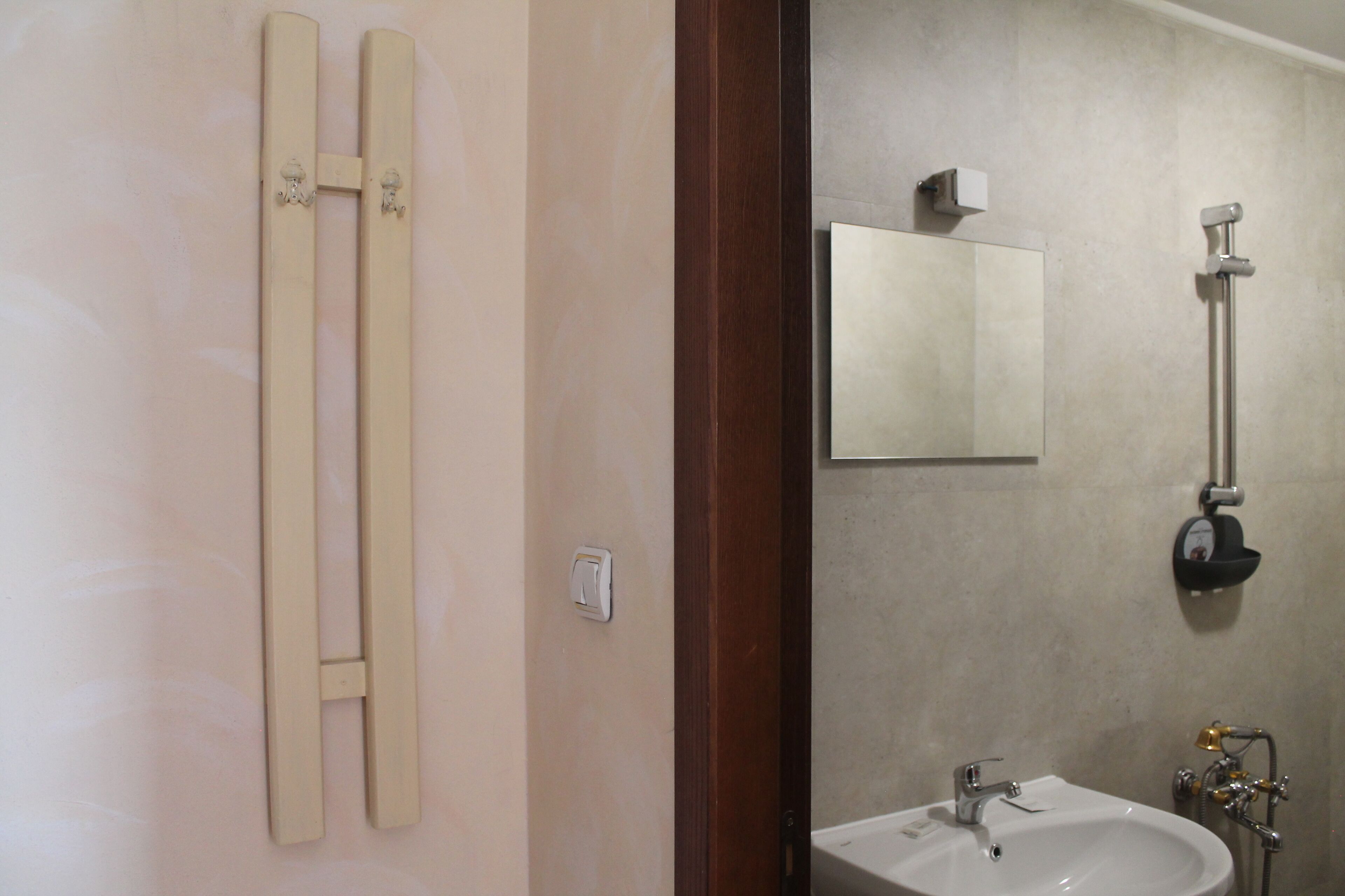A bathroom with a white sink, a mirror, and a towel rack.