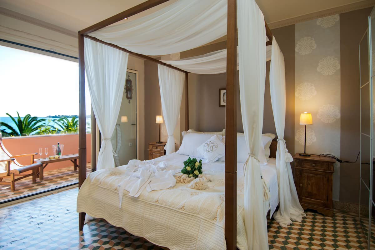 Una cama con dosel, un mesita de noche de madera con una lámpara y un suelo a cuadros.