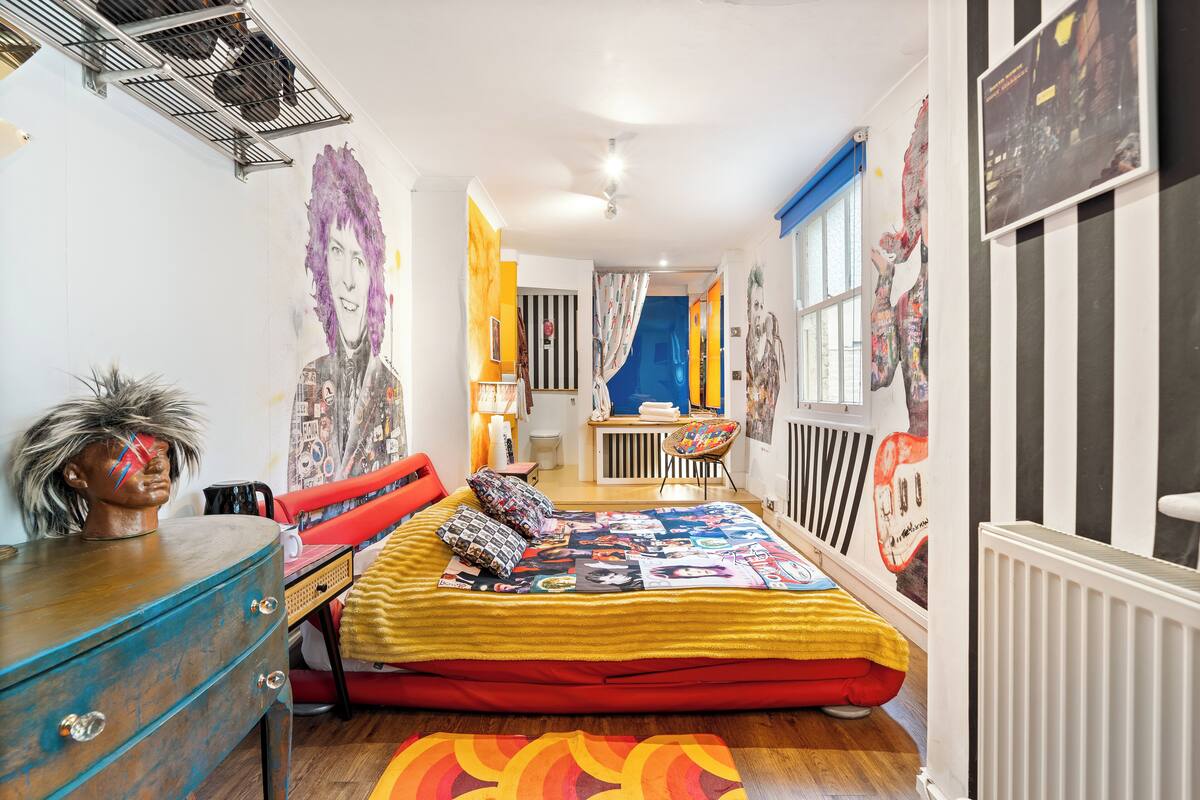 Ein Schlafzimmer mit einem Bett, einem Schminktisch, einem Sessel und einer Heizung.