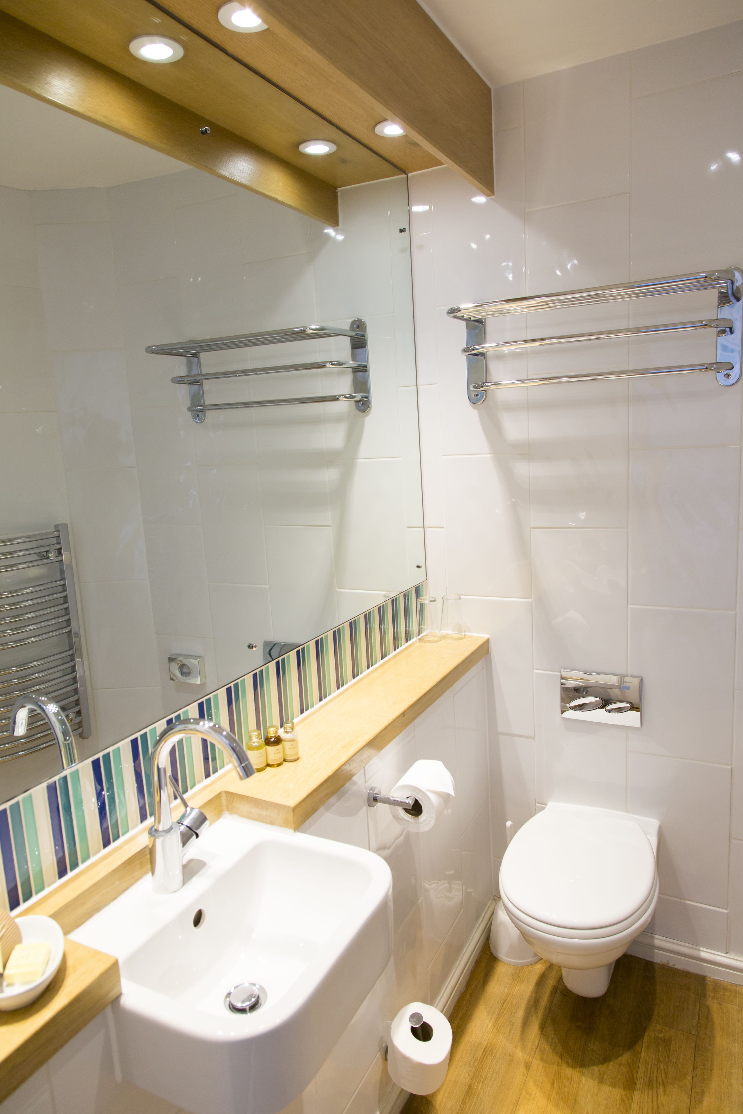 Een moderne badkamer met wastafel, spiegel en toilet.