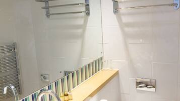 Een moderne badkamer met wastafel, spiegel en toilet.