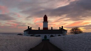 A lighthouse with a brick pathway leading to it, surrounded by snow-covered walls. - Beechwood Guest House (South Shields)
