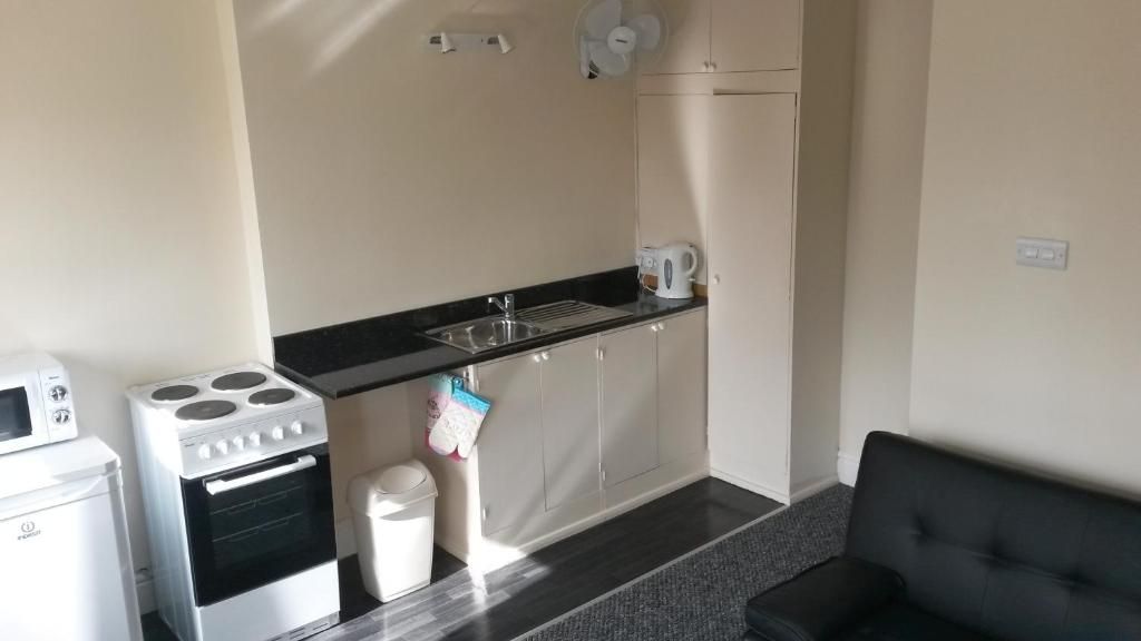 Una kitchenette funcional con estufa, pileta y alacenas.