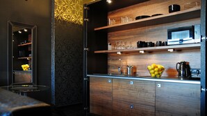A modern kitchen with wooden cabinets, a microwave, and a fruit bowl on the counter.