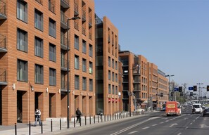 A modern brick building with multiple floors, large windows, and balconies.