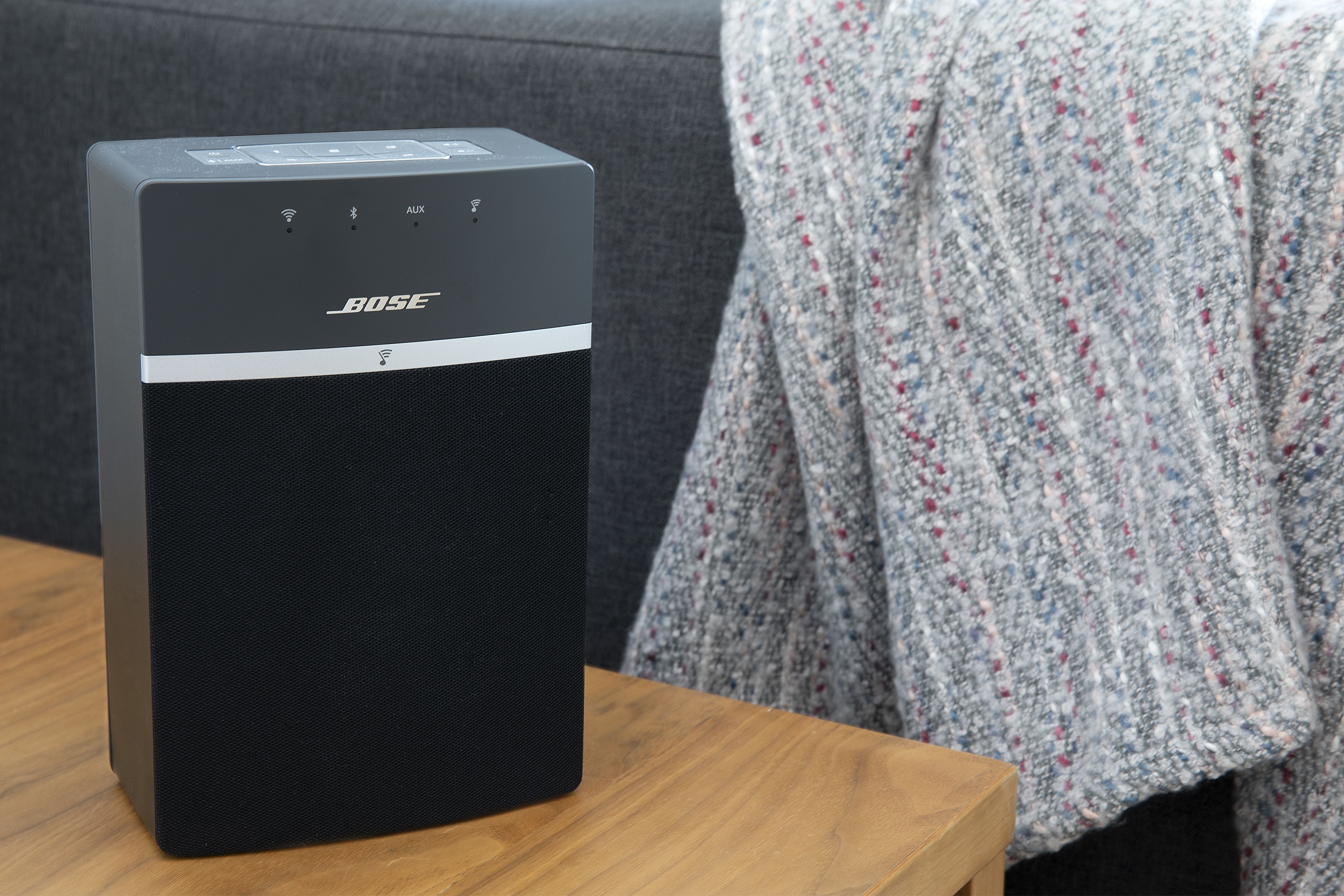 Un haut-parleur Bose noir posé sur une table en bois.
